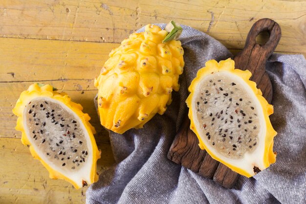 Frutta gialla del drago pitahaya su fondo di legno