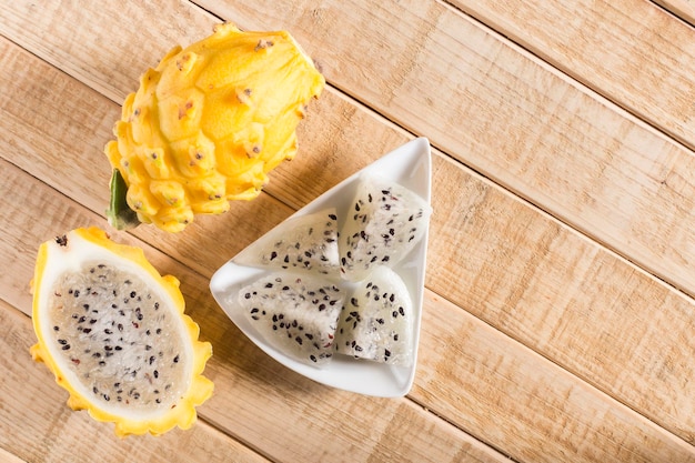 Frutta gialla del drago pitahaya su fondo di legno