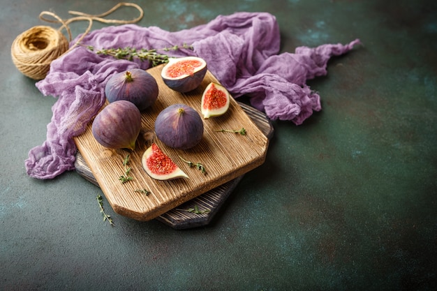 Frutta intera fresca succosa del fico e uno tagliato i fichi sul tagliere di legno