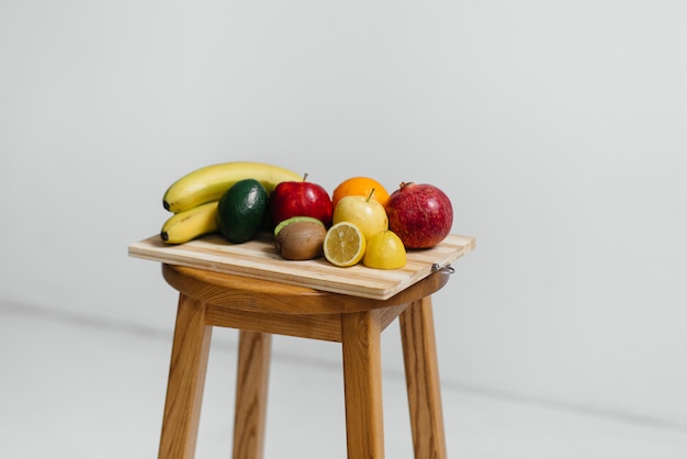 Frutta matura Assorted su una scheda di legno su una priorità bassa bianca. Dieta sana