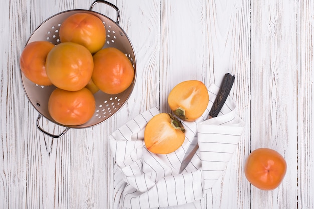 Frutta matura deliziosa del cachi su legno bianco