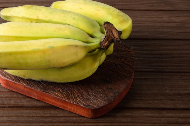 Frutta matura della banana isolata con fondo di legno scuro..