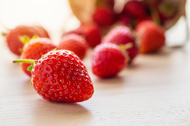 Frutta matura rossa organica fresca della fragola sul primo piano di legno del fondo