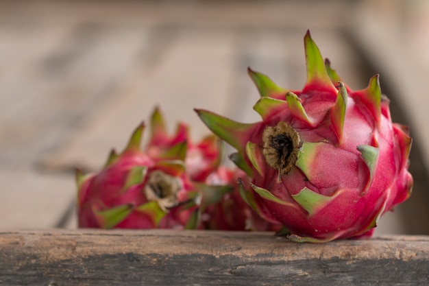 Frutta rossa del drago o frutta tropicale sullo sfondo della scrivania di legno