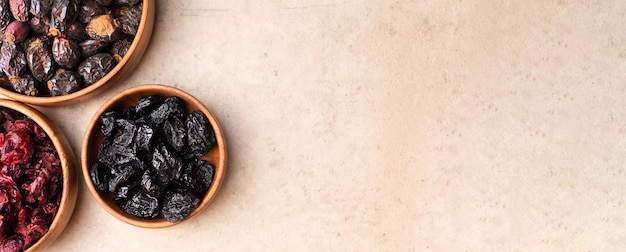 Frutta secca sana prugne di mirtillo rosso in una ciotola di legno vista dall'alto flatlay