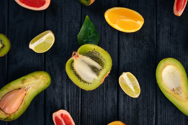 Frutta su uno sfondo di legno Avocado lime arancia pompelmo e kiwi Vista dall'alto Spazio libero per il testo