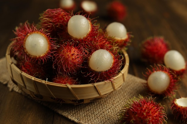 Frutta tropicale fresca del rambutan in un canestro con fondo di legno