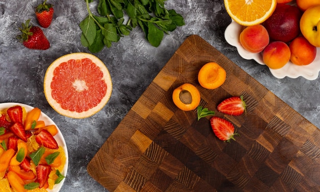 Frutti a fette sul tagliere di legno Fare un'insalata colorata come uno spuntino sano