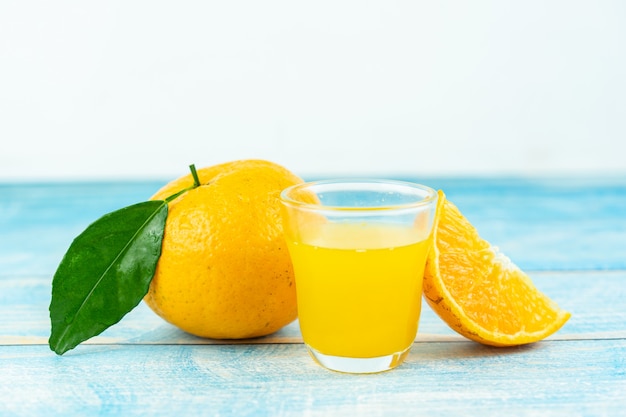 Frutti arancio e succo d'arancia sulla tavola di legno