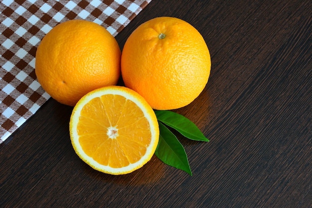 frutti arancioni con foglie su fondo di legno scuro, primo piano