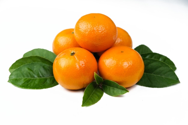 Frutti arancioni isolati bianchi con foglie verdi