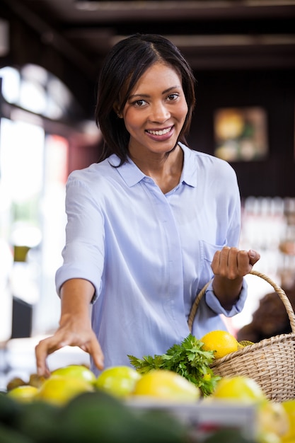 Frutti d'acquisto sorridenti della donna nella sezione organica