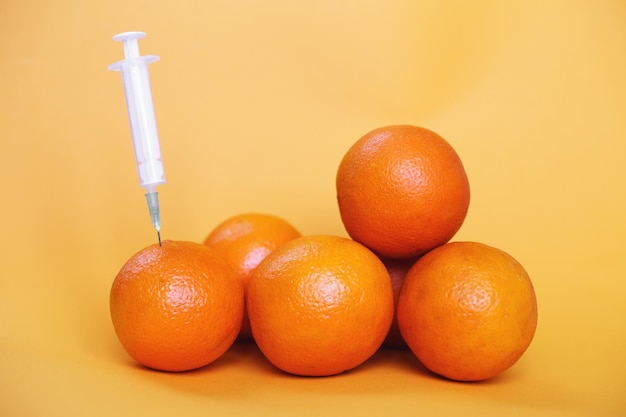 Frutti d'arancia con siringa estraente liquido con vitamina C cosmetici naturali antietà
