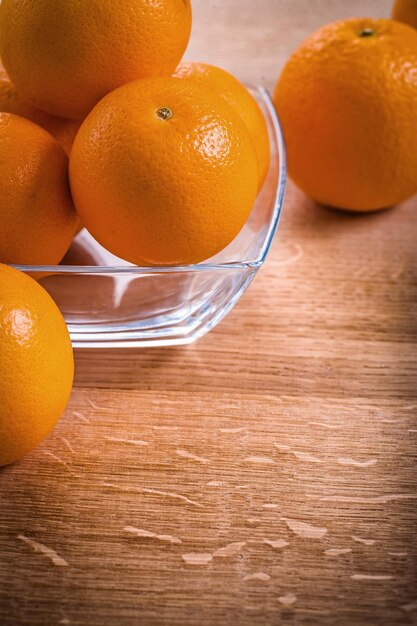Frutti d'arancia in una ciotola quadrata di vetro sulla scrivania in legno