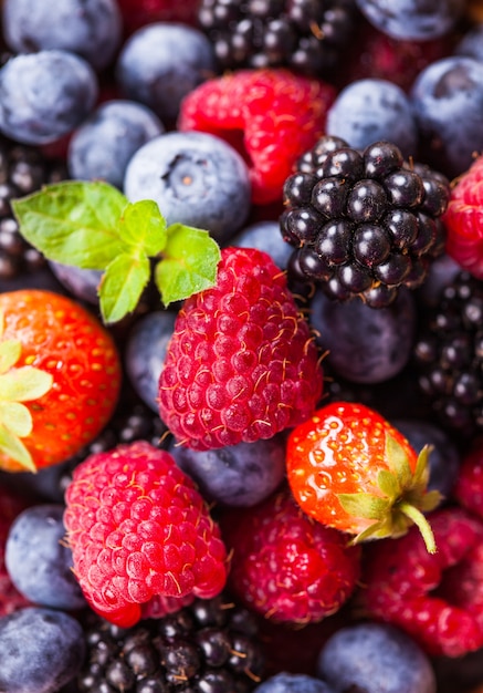 Frutti di bosco estivi come sfondo - lampone, fragola, mora e mirtillo