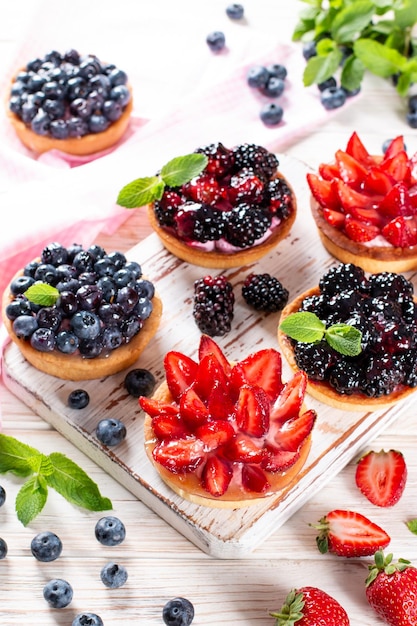 Frutti di bosco freschi e ricotta in tartletes Dessert estivo sana colazione mattutina o spuntino panini aperti con fragole, mirtilli, more