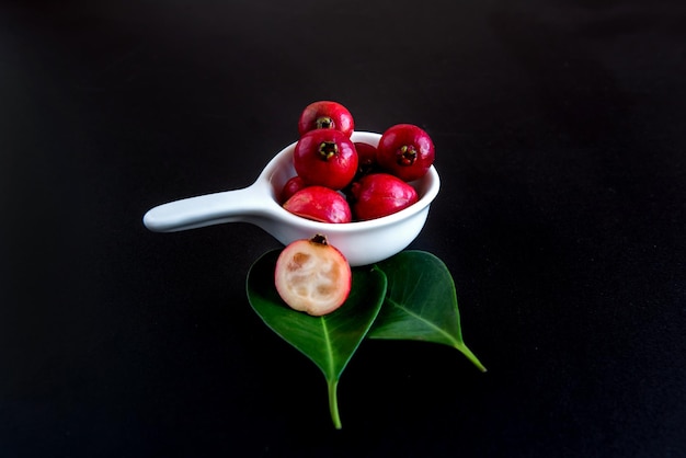 Frutti di guava fragola rossa su sfondo nero Psidium cattleyanum