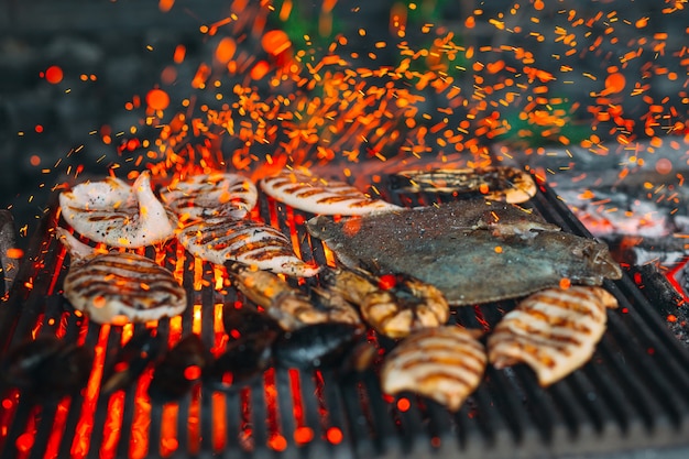 Frutti di mare alla griglia, cozze, gamberi, calamari e pesce sono cotti al fuoco.