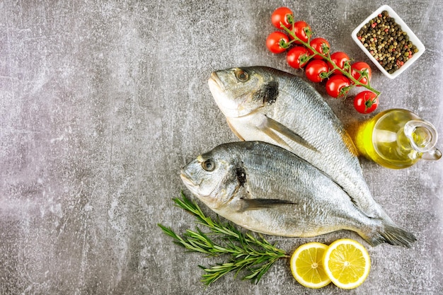 Frutti di mare pesce fresco dorado e ingredienti per cucinare su sfondo grigio Vista dall'alto con spazio per la copia