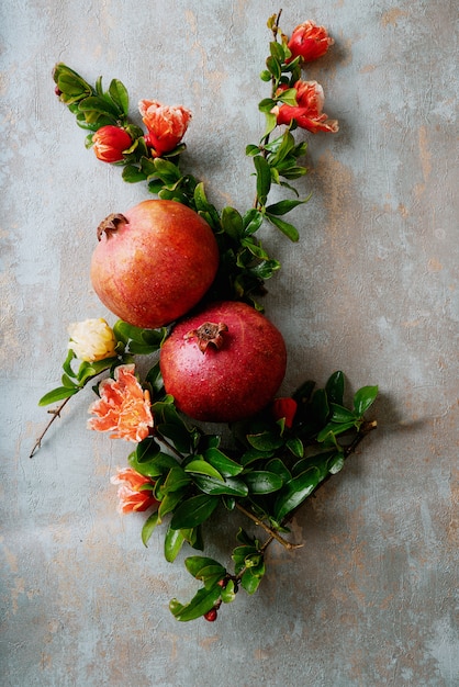 Frutti di melograno con rami fioriti