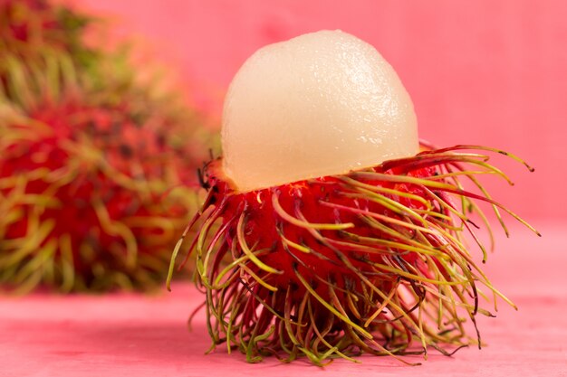 Frutti di Rambutan su legno color rosa