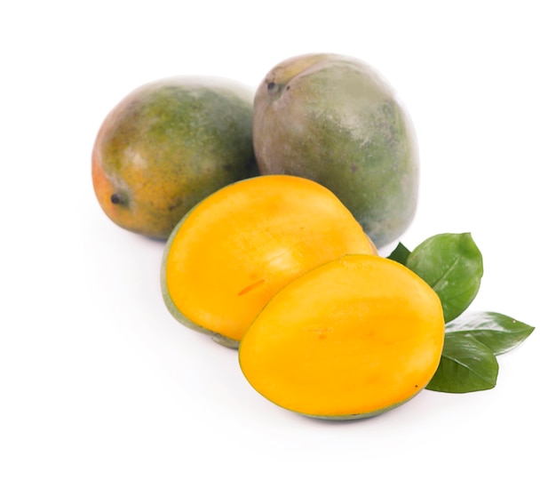 Frutti e foglie succosi esotici del mango isolati sulla superficie bianca