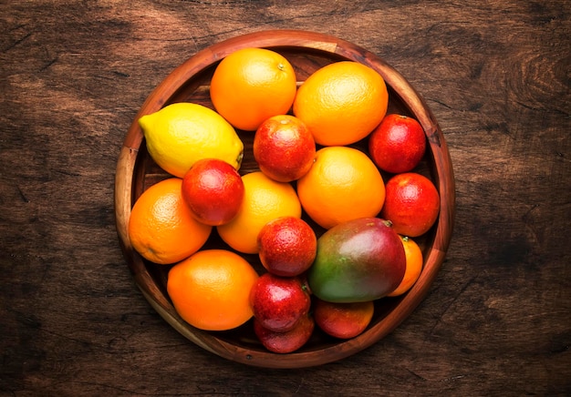 Frutti luminosi in grande vassoio arance limoni mango in assortimento Vista dall'alto