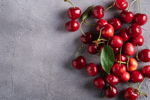 Frutti maturi freschi della ciliegia con le foglie verdi