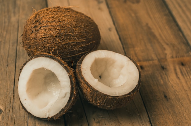 Frutti tropicali della noce di cocco su un fondo di legno nello stile rustico