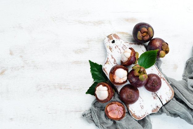 Frutti tropicali Mangostano su uno sfondo di legno bianco Vista dall'alto Spazio libero per il testo