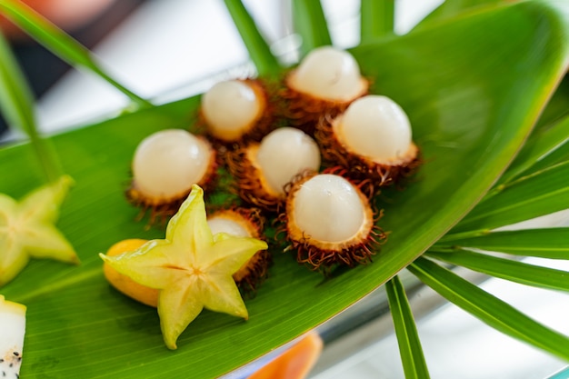 Frutti tropicali su una grande foglia verde all'esterno per gli ospiti.