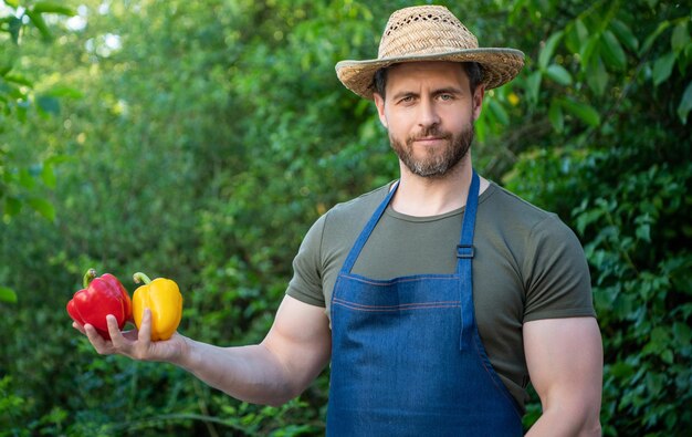 Fruttivendolo uomo in cappello di paglia con peperone