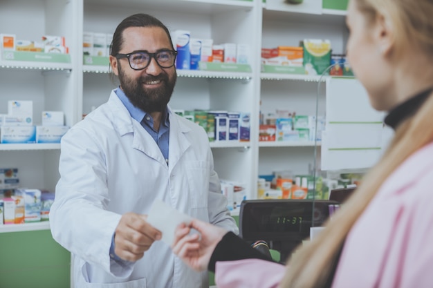 Fruttivista barbuto maturo che lavora in farmacia