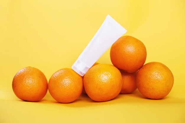 Frutto d'arancia con vitamina C e tubetto di crema vuoto naturale antietà e anticellulite