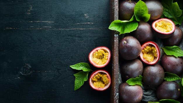 Frutto della passione fresco con foglie in scatola di legno Frutti tropicali Vista dall'alto Spazio libero per il testo