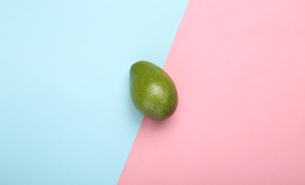 Frutto di avocado maturo su sfondo pastello blu rosa Vista dall'alto minima