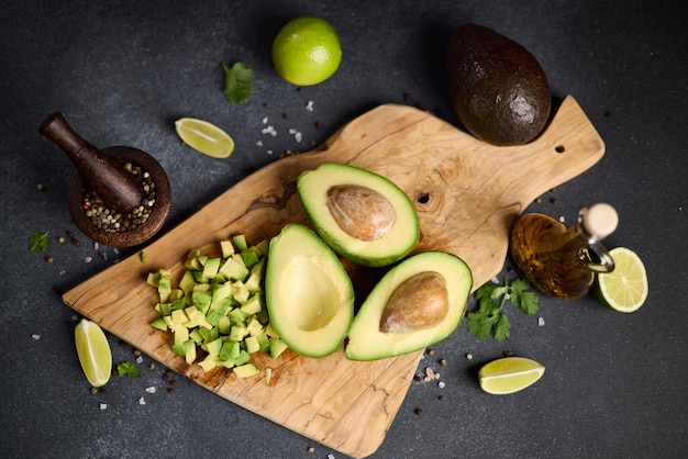 Frutto di avocado verde dimezzato su una tavola da taglio in legno in una cucina domestica