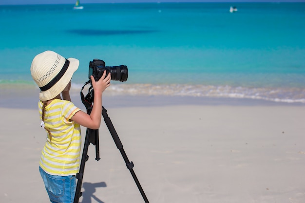 Fucilazione della bambina con la macchina fotografica sul treppiede durante le sue vacanze estive