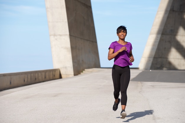 Full body in forma giovane donna nera jogging all&#39;aperto