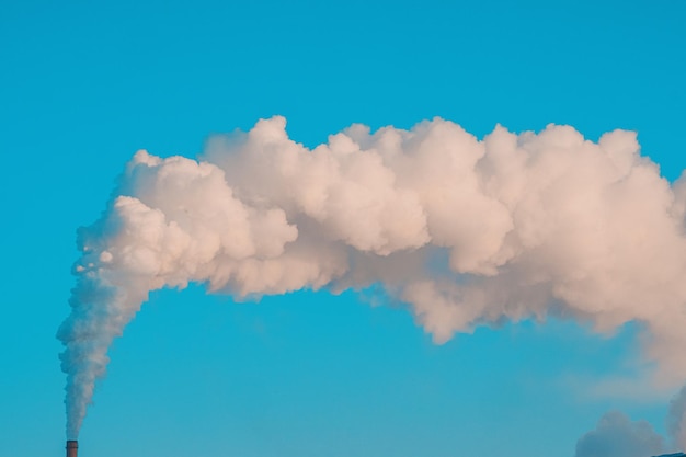 Fumo dal camino contro il cielo blu problema ecologico rilascio di anidride carbonica nell'atmosfera
