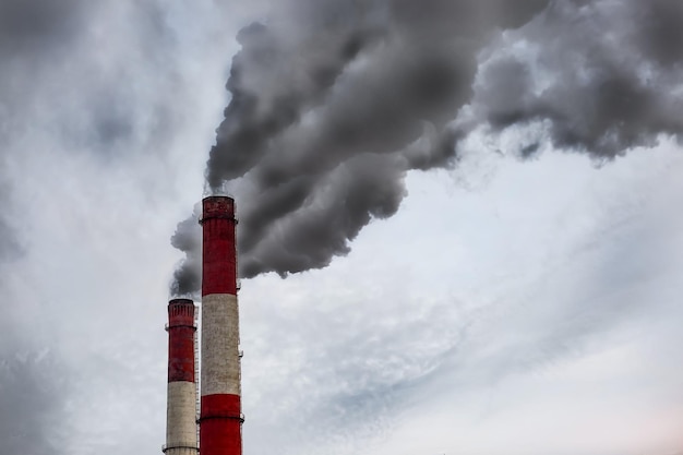 Fumo dalla pipa Tubi di fumo nelle aree industriali del cielo pennacchi di fumo neri