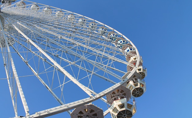 Funfair ruota panoramica Ferris su sfondo blu cielo.