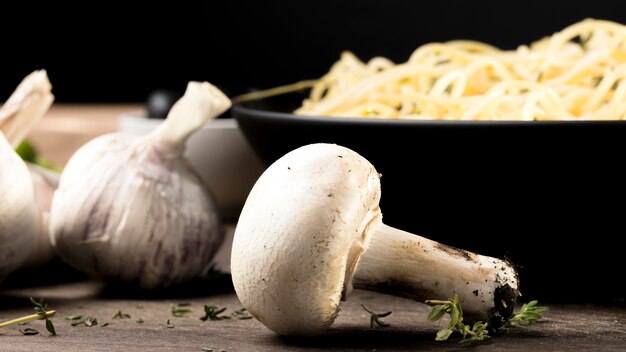 Funghi accanto al piatto con gli spaghetti