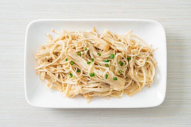 funghi aghi dorati saltati in padella con burro su piatto bianco