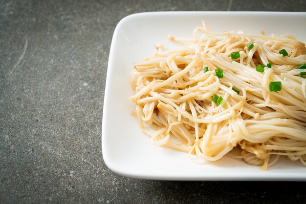 funghi aghi dorati saltati in padella con burro su piatto bianco