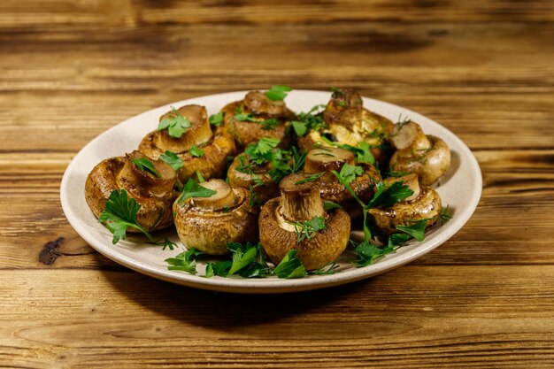 Funghi al forno in piatto sulla tavola di legno