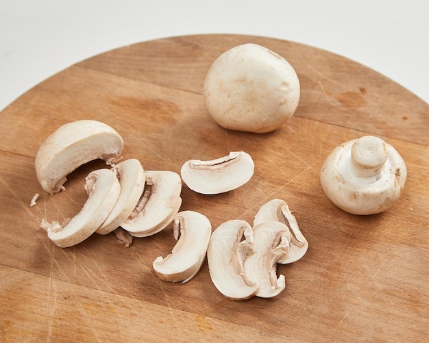 Funghi champignon affettati sul tagliere di legno