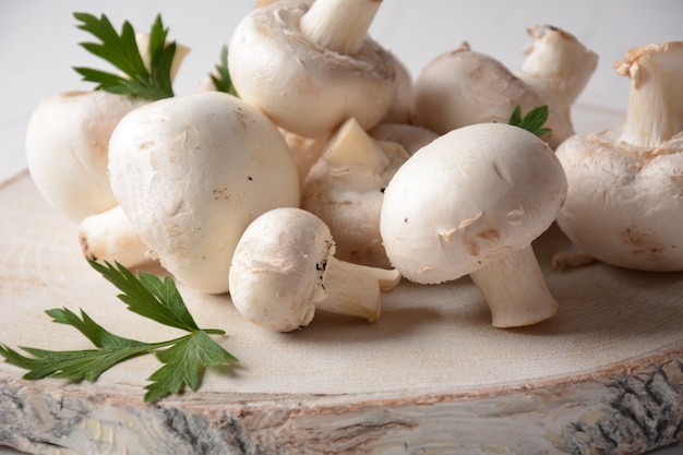 Funghi champignon bianchi freschi su tavola di legno