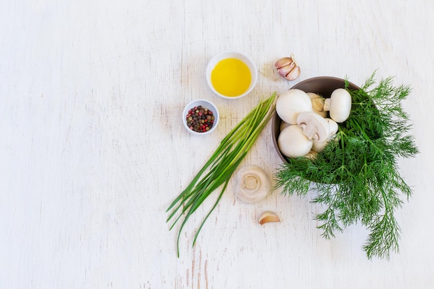 Funghi champignon ed erbe aromatiche in una ciotola, vista dall'alto, spazio per il testo