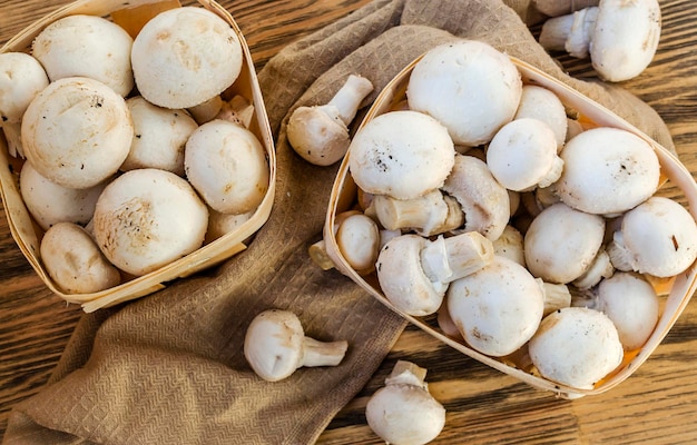 Funghi champignon freschi in un cestino sulla tavola di legno